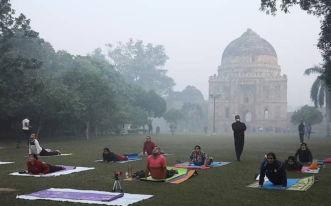현지시간으로 지난 16일 인도 뉴델리의 야외에서 요가를 하는 시민들. 뉴델리는 WHO 기준치의 20배를 웃도는 심각한 대기오염으로 곤혹을 치르고 있다. 사진=로이터 연합뉴스