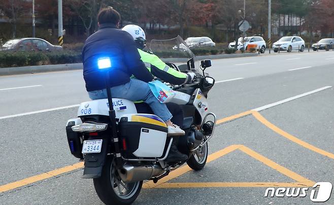 2022학년도 대학수학능력시험일인 18일 전북 전주시 전주사대부고 앞에서 고사장을 착각한 한 수험생이 경찰 오토바이를 타고 이동하고 있다. 2021.11.18/뉴스1 © News1 유경석 기자