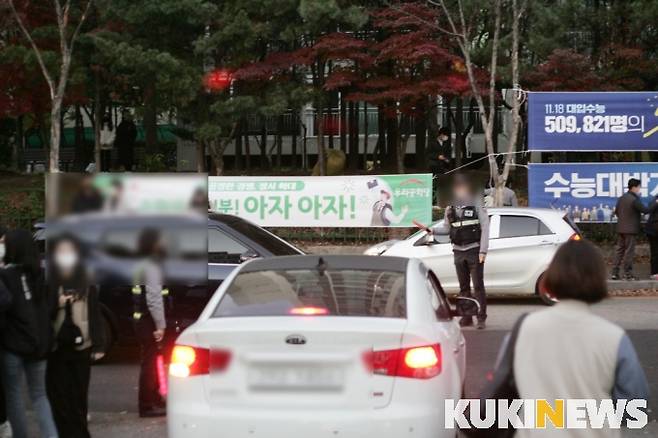 불법 주정차 차량으로 학교 앞이 혼잡한 5시 30분경, 교통경찰 2명이 교통 통제를 하고 있다. 