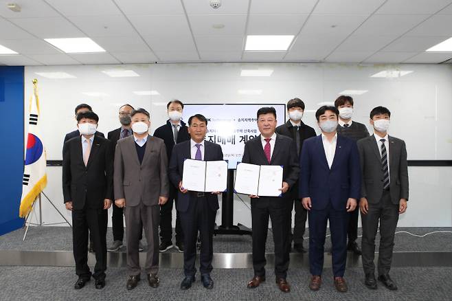 사천송지지역주택조합 김정근 조합장 한국테크놀로지 신용구 대표 및 관계자들이 기념 촬영을 하고 있다. [사진 제공 = 한국테크놀로지]