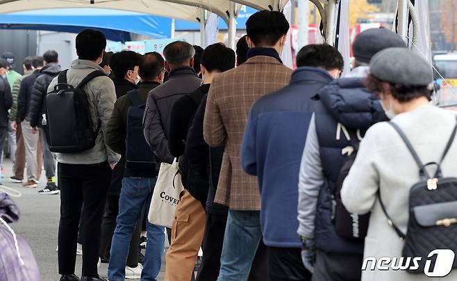 19일 오전 서울 중구 서울역 임시선별검사소에서 검사를 받으러 온 시민들이 길게 줄을 서 있다. 질병관리청 중앙방역대책본부는 이날 0시 기준 신종 코로나바이러스 감염증(코로나19) 신규 확진자가 3034명 발생했다고 밝혔다. 2021.11.19/뉴스1 © News1 박지혜 기자