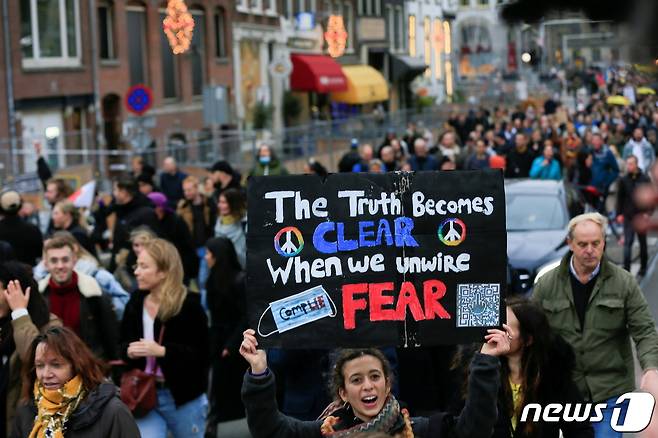 네덜란드에서 20일(현지시간) 정부의 코로나19 봉쇄 조치에 반대해 사람들이 거리에 모여 시위를 하고 있다. © 로이터=뉴스1 © News1 원태성 기자