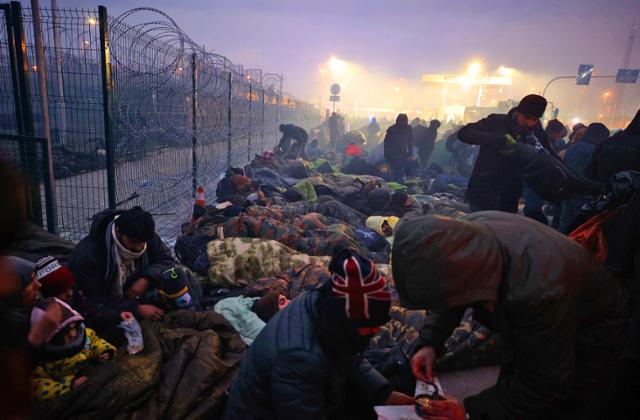 전쟁을 피해 벨라루스로 건너 온 중동 출신 난민들이 15일 벨라루스와 폴란드 국경인 브루즈기-쿠즈니차 국경검문소 주변 철조망에서 오도 가도 못한 채 갇혀 있다. AP 연합뉴스