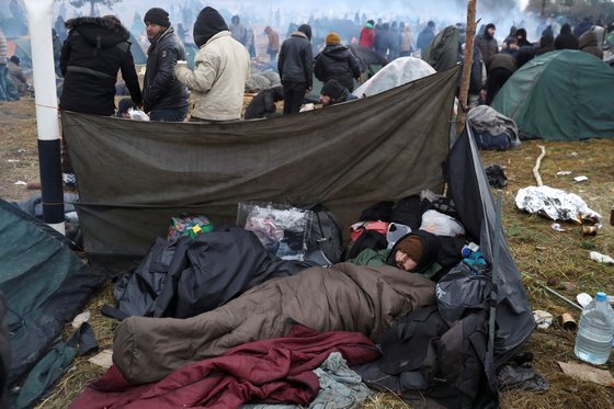 폴란드 국경 앞에서 중동 난민이 누워 있다. 연합뉴스