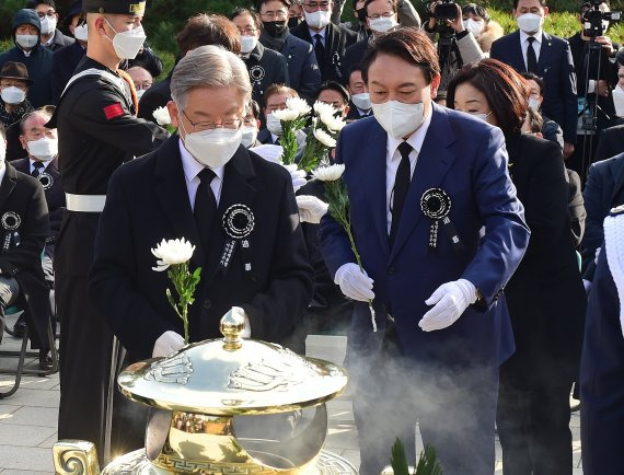 [서울=뉴시스] 국회사진기자단 = 더불어민주당 이재명(왼쪽), 국민의힘 윤석열 대선 후보가 22일 서울 동작구 국립서울현충원 내 김영삼 전 대통령 묘역에서 열린 6주기 추모식에서 헌화를 하고 있다.