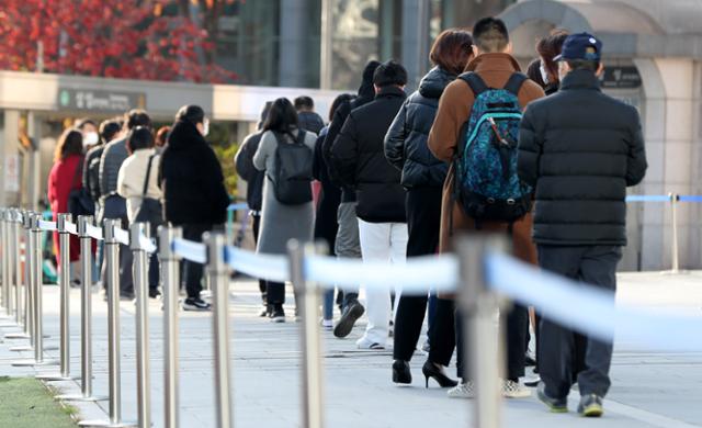 22일 서울 강남구 코엑스 앞에 설치된 코로나19 임시 선별검사소에서 검사를 받으려는 시민들이 줄을 서 있다. 뉴시스