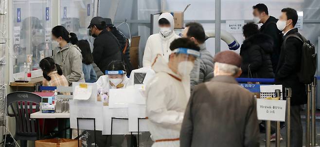 22일 서울 송파구 보건소에 마련된 선별진료소를 찾은 시민들이 신종 코로나바이러스 감염증(코로나19) 진단검사를 받기 위해 길게 줄을 서 차례를 기다리고 있다. 뉴스1