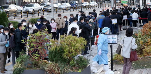 22일 오전 서울 송파구 보건소에 마련된 선별진료소를 찾은 시민들이 길게 줄을 서 검사 차례를 기다리고 있다. 뉴스1