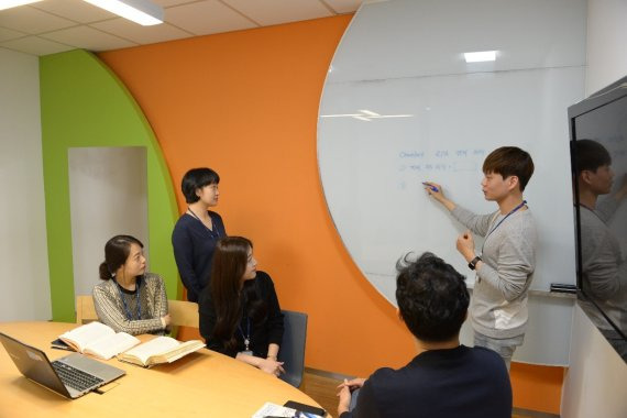 포스코ICT가 직급 호칭을 없애고 '프로'로 단일화해 수평적 조직으로 탈바꿈한다. 포스코ICT 직원들이 23일 회의실에서 회의를 하고 있다.