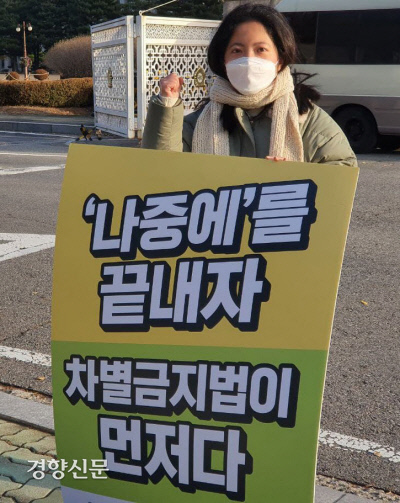 이심지 서울인권영화제 상임활동가가 23일 국회 정문 앞에서 연내 차별금지법 제정을 촉구하는 팻말을 들고 1인 시위를 하고 있다.