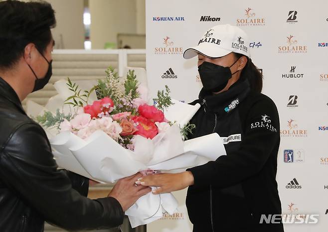 [인천공항=뉴시스] 고승민 기자 = 미국 여자프로골프(LPGA) 투어 2021 시즌 최종전에서 우승하며 다승왕, 상금왕과 올해의 선수상까지 석권하는 '3관왕'을 달성하고 금의환향한 고진영이 23일 오후 인천국제공항 제2터미널을 통해 귀국, 꽃다발을 받고 있다. 2021.11.23. kkssmm99@newsis.com