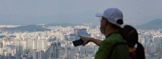 시민들이 서울 남산에서 서울 아파트 밀집 지역을 내려다보고 있다. <연합뉴스>