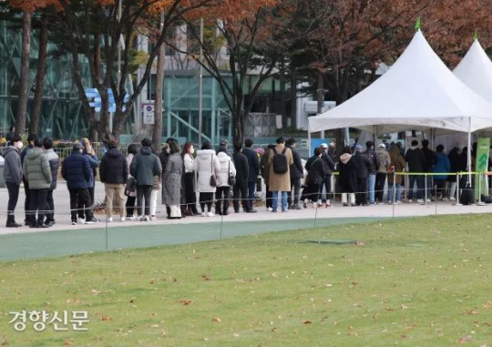 On November 23, citizens stand in a long line waiting to get tested at a temporary screening clinic installed in the plaza in front of Seoul City Hall. Kang Yoon-joong