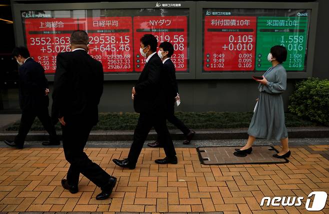 (도쿄 로이터=뉴스1) 노선웅 기자 = 1일 도쿄에서 마스크를 쓴 시민들이 세계 주가지수가 표시된 전광판을 지나고 있다.  (C) 로이터=뉴스1