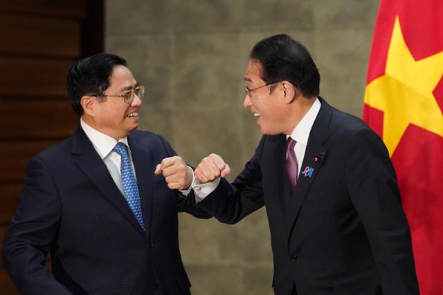 지난 24일 팜민찐(왼쪽) 베트남 총리가 일본 총리관저에서 열린 정상회담 전 기시다 후미오 신임 일본 총리와 웃으며 팔꿈치 인사를 하고 있다. 도쿄=EPA 연합뉴스