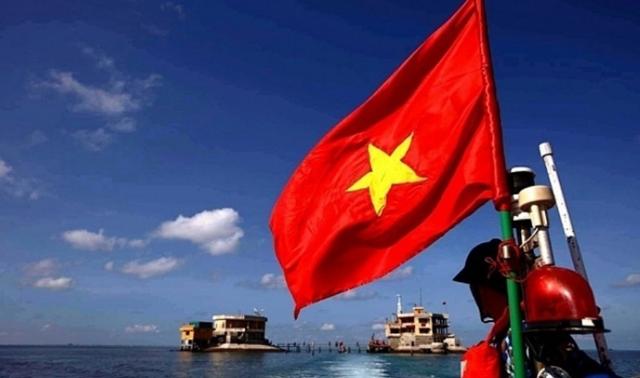 베트남의 한 군인이 중국과 영유권 분쟁으로 갈등을 빚고 있는 남중국해 인근에서 국기를 들고 보초를 서고 있다. VN익스프레스 캡처