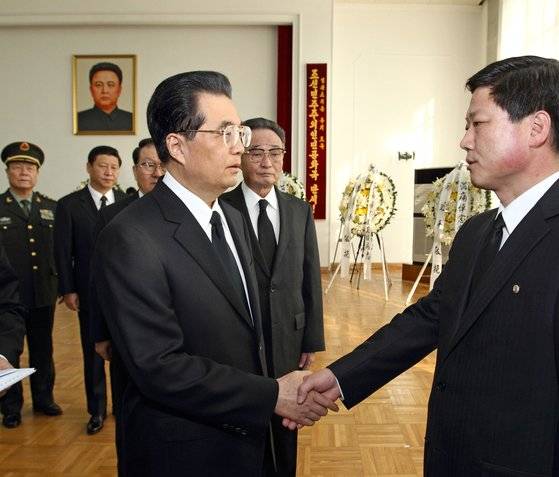 지난 2011년 12월 20일 후진타오(가운데) 중국공산당 전 총서기가 베이징 주중 북한 대사관에 마련된 김정일 빈소를 찾아 조문하고 있다. 뒷쪽 김정일 사진 밑으로 시진핑 당시 국가부주석이 보인다. [신화=연합뉴스]