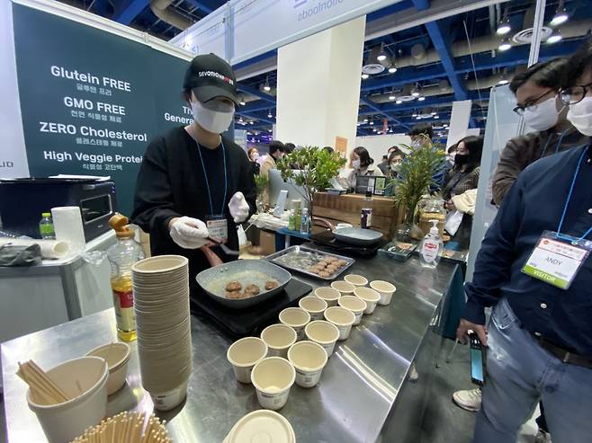 지난 26일 서울 강남구 코엑스에서 개막한 2021 푸드위크 전시장에서 방문객이 대체육 고기를 맛보고 있다. [신주희 기자]