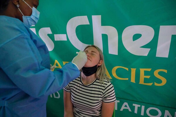 남아프리카공화국 요하네스버그 국제공항에서 의료 관계자가 여행객 코로나19 유전자 증폭(PCR) 검사를 하고 있다. 요하네스버그/AFP 연합뉴스