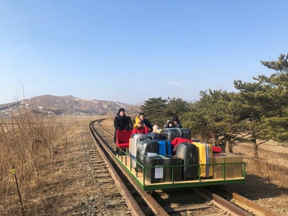 북한 주재 러시아 외교관들이 신종 코로나바이러스 감염증(코로나19)으로 국경이 봉쇄되자 귀국길에 직접 수레를 밀며 국경을 건너는 모습. [연합뉴스]