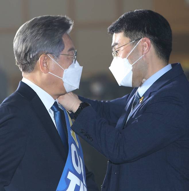 [원주=뉴시스] 김경목 기자 = 12일 오후 이재명 더불어민주당 대선 경선 후보의 수행비서인 김남국 의원이 강원도 원주시 오크밸리 리조트 컨벤션홀에서 열린 제20대 대통령선거 후보자 선출을 위한 합동연설회에 행사장에서 어깨띠를 걸어주고 있다. 2021.09.12.