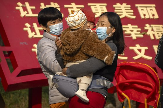 베이징 한 공원에서 마스크를 쓴 부모가 아이를 안고 있다. [AP=연합뉴스]