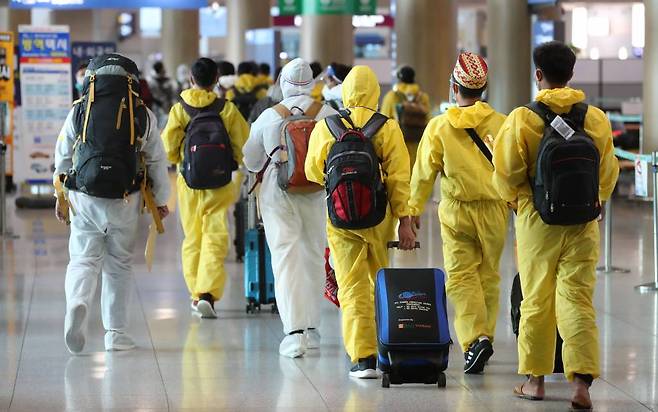 [인천공항=뉴시스] 배훈식 기자 = 코로나19 변이 바이러스 오미크론 유입 차단을 위해 남아공 등 8개국 발 외국인 입국이 제한된 29일 오전 인천국제공항 제1터미널에서 방호복을 착용하고 입국한 외국인들이 이동하고 있다. 2021.11.29.