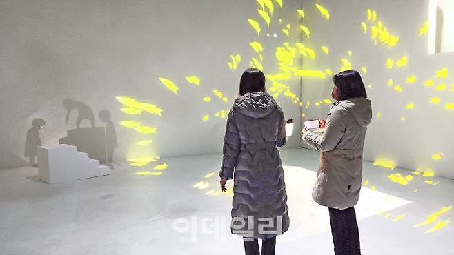 문준용의 미디어아트 ‘어그먼티드 섀도: 별을 쫓는 그림자들’에 참여한 관람객들. 그중 한 관람객이 컵처럼 생긴 손전등을 들고 그림자에게 빛을 전달하는 중이다. 누군가 나서 교감을 주도해야 하는 인터랙션은 문 작가 작업에서 핵심이다(사진=오현주 문화전문기자).