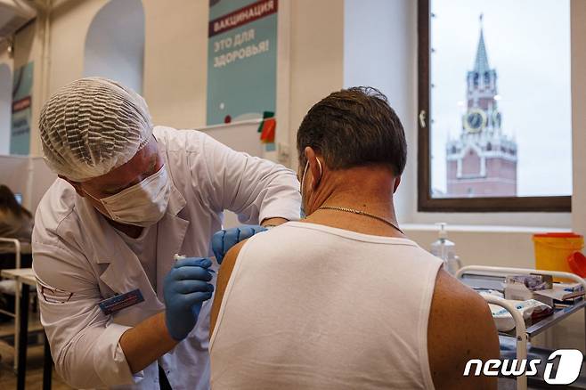21일(현지시간) 러시아 모스크바의 백화점에 마련된 코로나19 백신 접종소에서 환자가 스푸트니크 V 백신을 맞고 있다. © AFP=뉴스1 © News1 우동명 기자