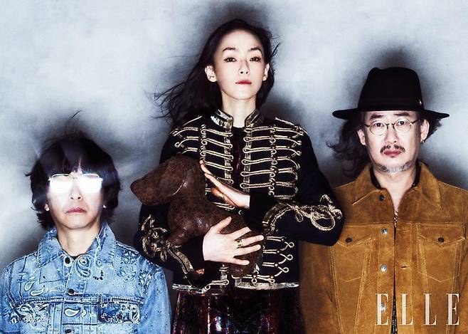 김진만이 입은 데님 재킷은 Amiri by Mr Porter. 빈티지 무드의 골드 프레임 안경은 Gentle Monster. 이너 웨어로 입은 니트 톱은 스타일리스트 소장품. 김윤아가 입은 밀리터리 재킷과 드레스는 모두 Etro. 골드 링은 모두 Jem & Pebbles. 이선규가 착용한 블랙 페도라는 Shinjeo. 골드 네크리스는 Jem & Pebbles. 스웨이드 레더 재킷과 블랙 블라우스는 모두 스타일리스트 소장품.