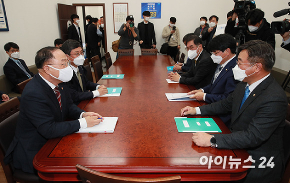 윤호중(오른쪽) 더불어민주당 원내대표와 홍남기 경제부총리 겸 기획재정부 장관이 30일 서울 여의도 국회에서 열린 예산협의에서 악수하고 있다. [사진=김성진 기자]