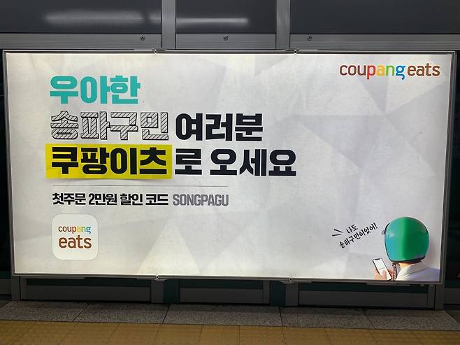 최근 주요 지하철역 플랫폼에 게제된 쿠팡이츠 광고. “우아한 OO구민 여러분 쿠팡이츠로 오세요” 라며 배달의민족 운영사 ‘우아한형제들’을 에둘러 표현하고 있다. [독자 제공]