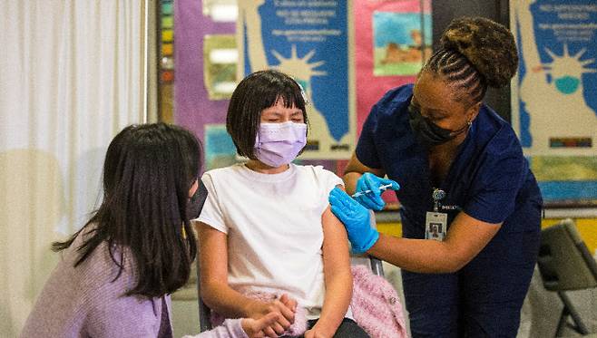 미국 뉴욕시의 한 코로나19 백신 접종소에서 10세 여학생이 주사를 받으며 울고 있다. (사진=AFP 제공)
