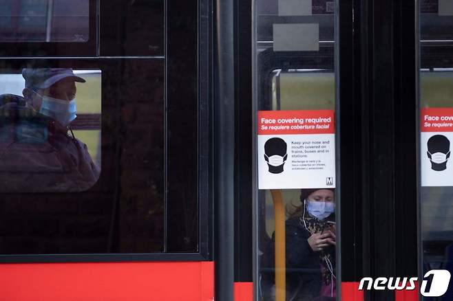 미국 워싱턴D.C의 한 버스 출입문에 마스크 착용 의무 관련 안내문이 붙어 있다. 2021.01.12 © AFP=뉴스1