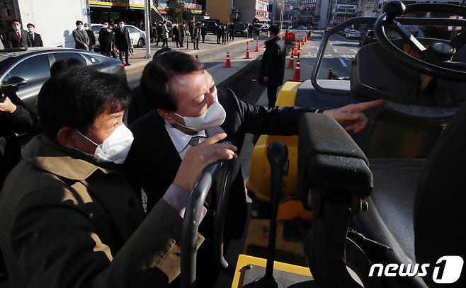 윤석열 국민의힘 대선 후보가 2일 오전 경기 안양시 안양동 안양여고 인근 도로포장 공사 사망사고 현장을 찾아 관계자에게 상황을 브리핑 받고 있다. 2021.12.2/뉴스1 © News1 김진환 기자