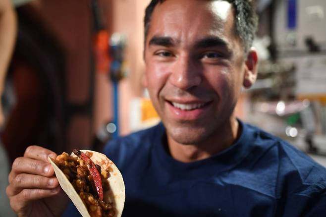 미국 항공우주국(NASA) 소속 우주비행사이자 익스패디션 66 엔지니어인 라자 차리가 우주 고추로 만든 타코를 들고 있다. 사진=NASA