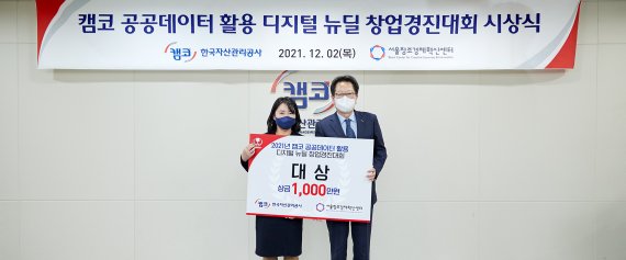 신흥식 사장 직무대행(오른쪽)이 2일 서울 도곡동 캠코 양재타워에서 개최된 '공공데이터 활용 창업경진대회' 시상식에서 대상을 수상한 이지은 평행공간 대표에게 상금을 전달하고 기념촬영을 하고 있다. 캠코 제공
