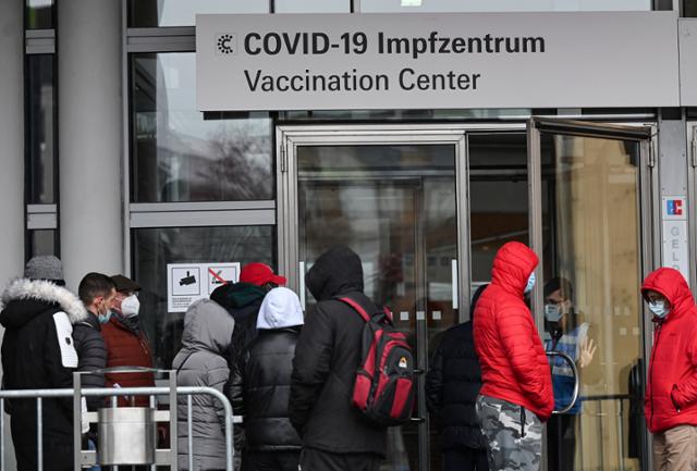 지난달 30일 독일 프랑크푸르트의 한 신종 코로나바이러스 감염증 백신 접종소에 사람들이 줄을 길게 서 있다. 프랑크푸르트=AP 연합뉴스