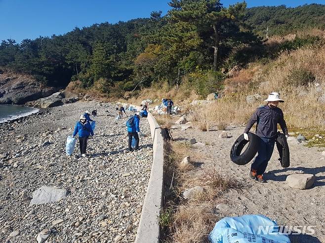 [통영=뉴시스] 홍정명 기자= 2일 경남 통영시 추도를 찾은 '경남 섬 서포터즈' 회원들이 해안변 환경정화 활동을 하고 있다.(사진=경남도 제공) 2021.12.02.  photo@newsis.com