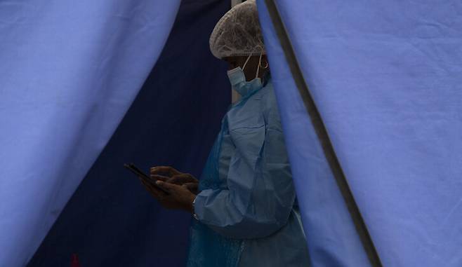 2일 남아프리카공화국의 소웨토에서 한 의료진이 휴대전화를 사용하고 있다. 소웨토/AP 연합뉴스