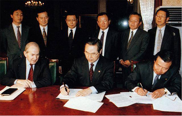 1997년 12월 3일 정부종합청사에서 임창렬(앞 줄 가운데) 경제부총리와 이경식(오른쪽) 한국은행 총재가 캉드쉬 IMF 총재가 지켜보는 가운데 IMF긴급자금 지원을 받기 위한 정책 의향서에 서명하고 있다. 1997. 12. 3. 오대근 기자