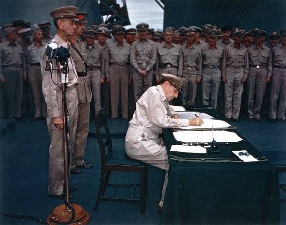 1945년 9월 2일 더글러스 맥아더 장군이 도쿄항에 정박 중인 미 태평양 함대 소속 미주리호 선상에서 일본의 항복 문서에 서명하고 있다. [중앙포토]