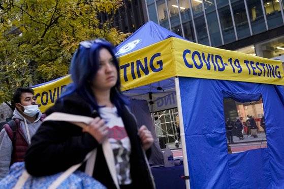2일 미국 뉴욕 맨해튼에 설치된 선별진료소 천막을 행인들이 마스크를 쓰지 않은 채 지나가고 있다. 사진=AP 연합뉴스