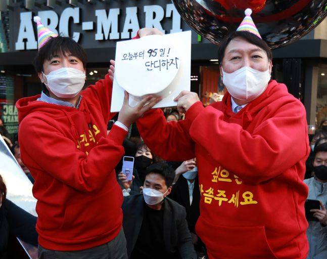 국민의힘 윤석열 대선후보와 이준석 대표가 4일 오후 부산 서면 젊음의 거리에서 윤 후보 생일 케이크를 들고 포즈를 취하고 있다. 생일 케이크에는 '오늘부터 95일 단디하자'라는 문구가 적혀 있다. ⓒ연합뉴스