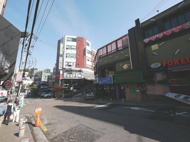 후커힐로 들어가는 입구에 있는 펍 ‘pearl’ 과 길을 따라 들어선 클럽들이 보인다. 후커힐의 골목 입구 도로에는 '청소년 출입금지'가 쓰여 있고, 오르막길 좌우에는 1, 2층의 오래된 건물에 영어로 된 간판들이 틈 없이 이어져 있다. 서울역사박물관 제공