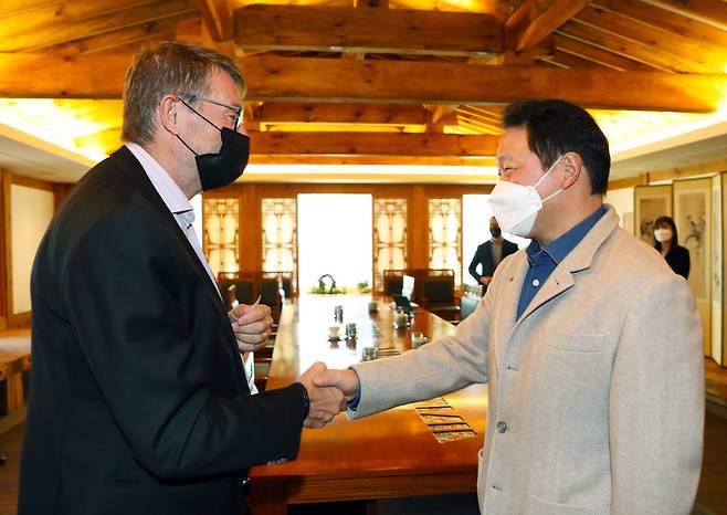 최태원 SK 회장(오른쪽)이 지난 3일 서울 종로구 SK서린빌딩에서 스웨덴 발렌베리그룹의 투자 전문기업 EQT파트너스 콘니 욘슨 회장을 만나 악수하고 있다. /SK그룹 제공.