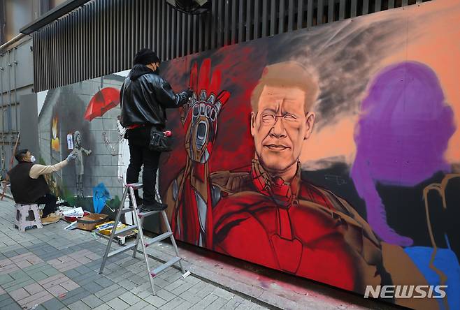 [서울=뉴시스] 배훈식 기자 = 보수와 진보성향 탱크시(왼쪽), 닌볼트 그래비티 작가가 5일 오후 서울 종로구의 한 중고서점 외벽에 각각 이재명 더불어민주당 대선 후보와 윤석열 국민의힘 대선후보의 벽화를 그리며 아트배틀을 펼치고 있다. 2021.12.05. dahora83@newsis.com
