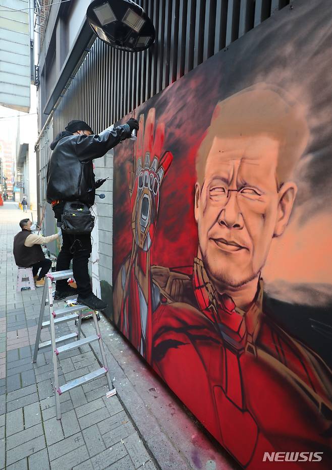 [서울=뉴시스] 배훈식 기자 = 보수와 진보성향 탱크시(왼쪽), 닌볼트 그래비티 작가가 5일 오후 서울 종로구의 한 중고서점 외벽에 각각 이재명 더불어민주당 대선 후보와 윤석열 국민의힘 대선후보의 벽화를 그리며 아트배틀을 펼치고 있다. 2021.12.05. dahora83@newsis.com