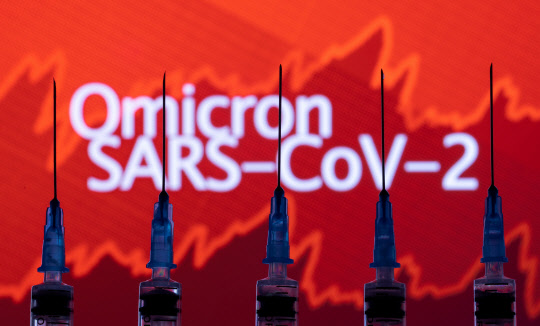 FILE PHOTO: Syringes with needles are seen in front of a displayed stock graph and words "Omicron SARS-CoV-2" in this illustration taken, November 27, 2021. REUTERS/Dado Ruvic/Illustration/File Photo