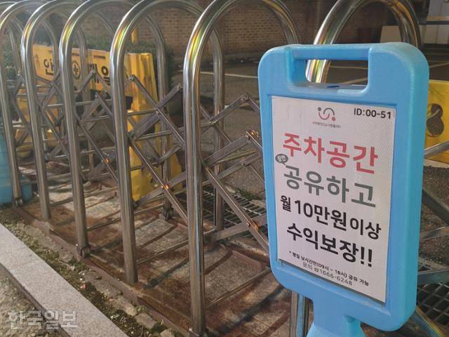 지난달 30일 서울시 양천구 목동 한 아파트 단지 부근에 주차 공간을 공유하면 월 10만원 이상의 수익을 보장한다는 내용의 안내판이 세워져 있다. 김재현 기자